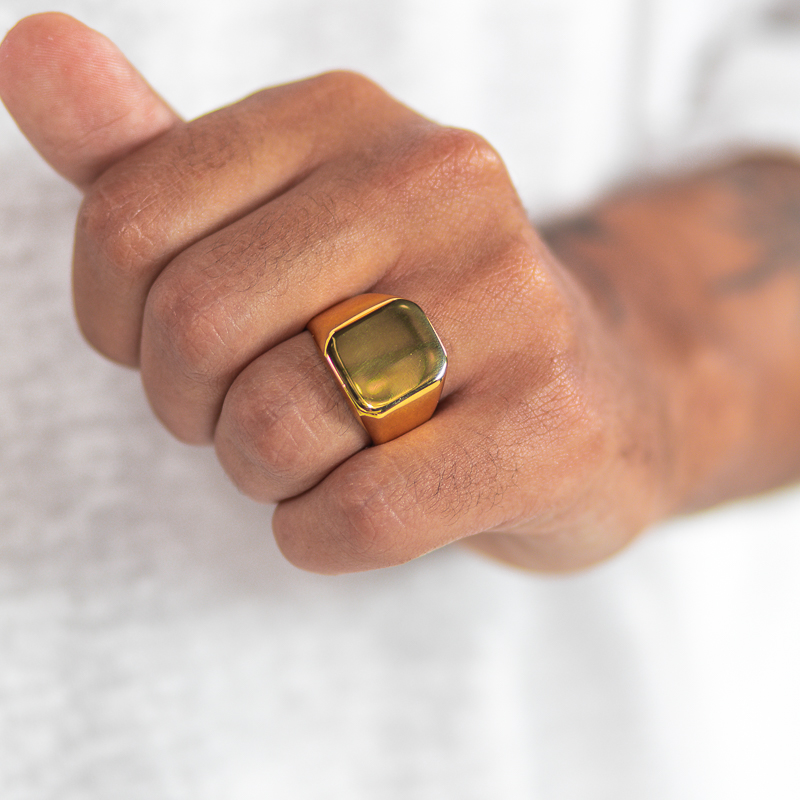 טבעת מוזהבת לגבר "יוסטון" מסטיינלס סטיל על קמיצה של דוגמן יד שמאל צמודה לבטן זום על היד